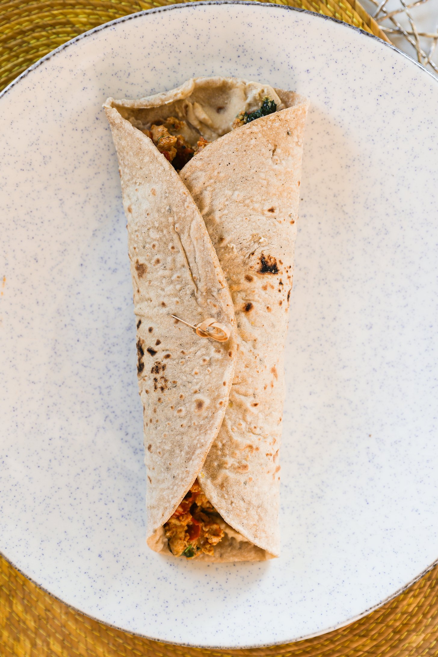 Top view snapshot displaying an Egg Bhurji Wrap neatly sealed with a knotted wooden pick