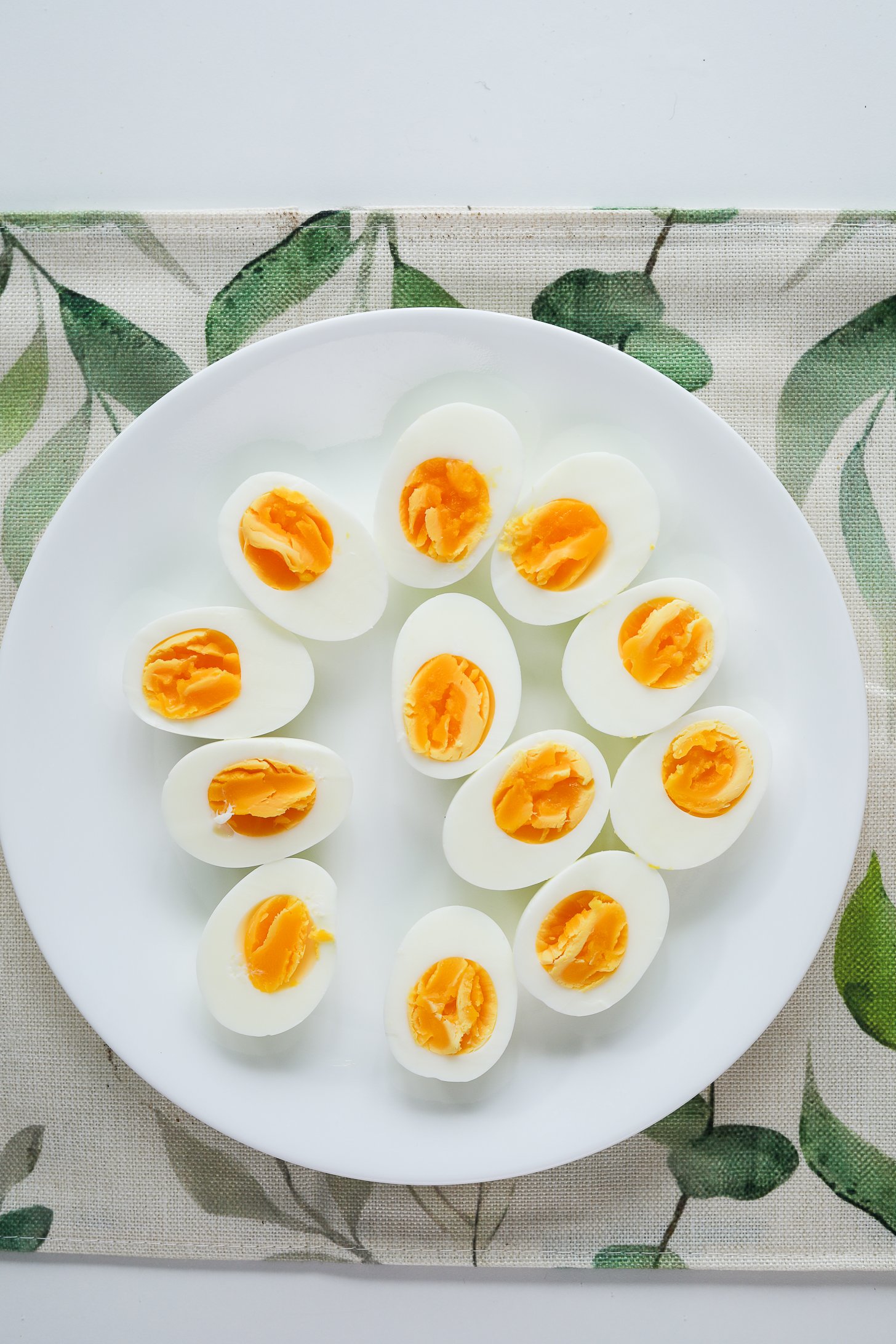 Top view of plate of sliced boiled eggs.