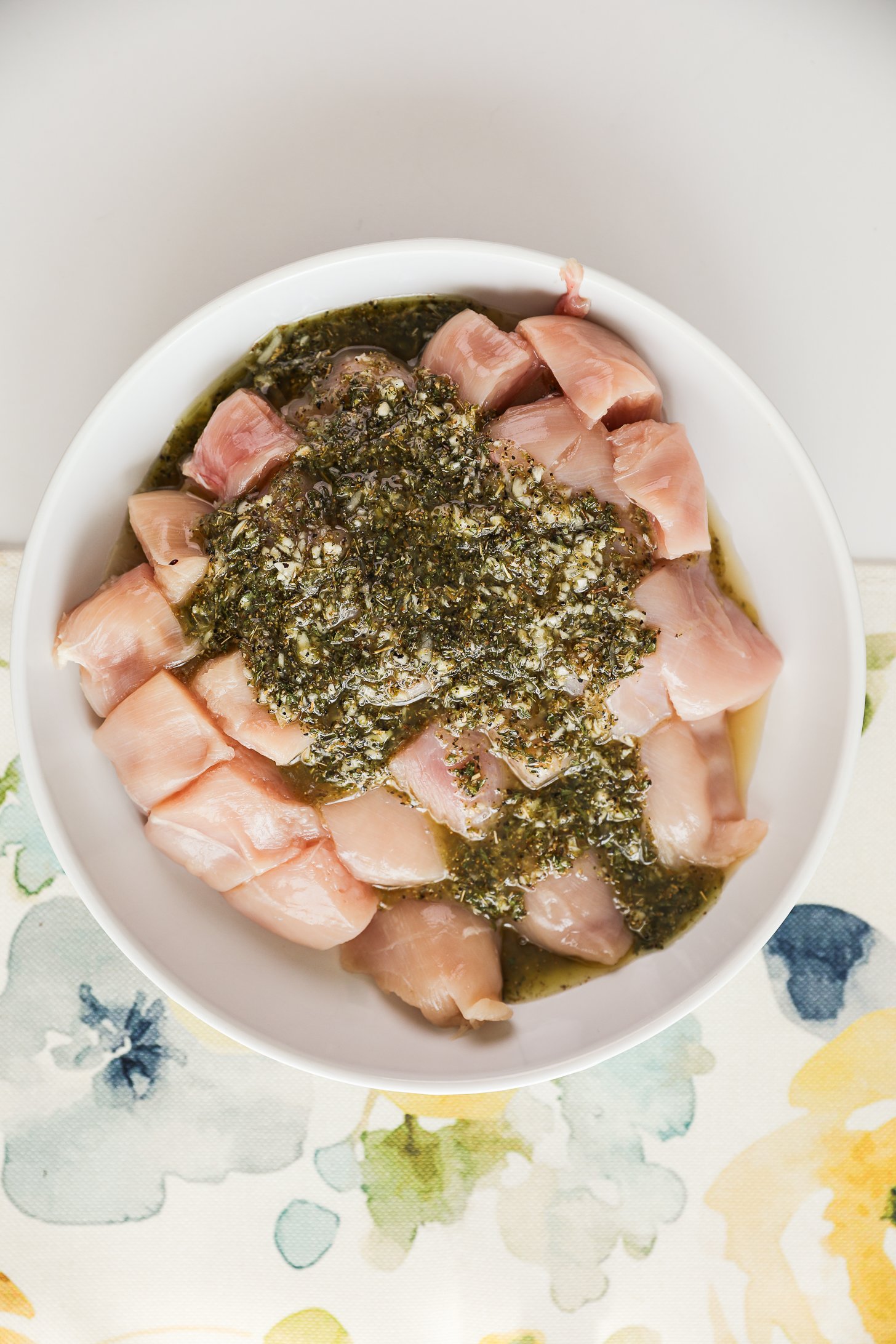 Raw chicken breast cubes topped with a oily herb marinate.