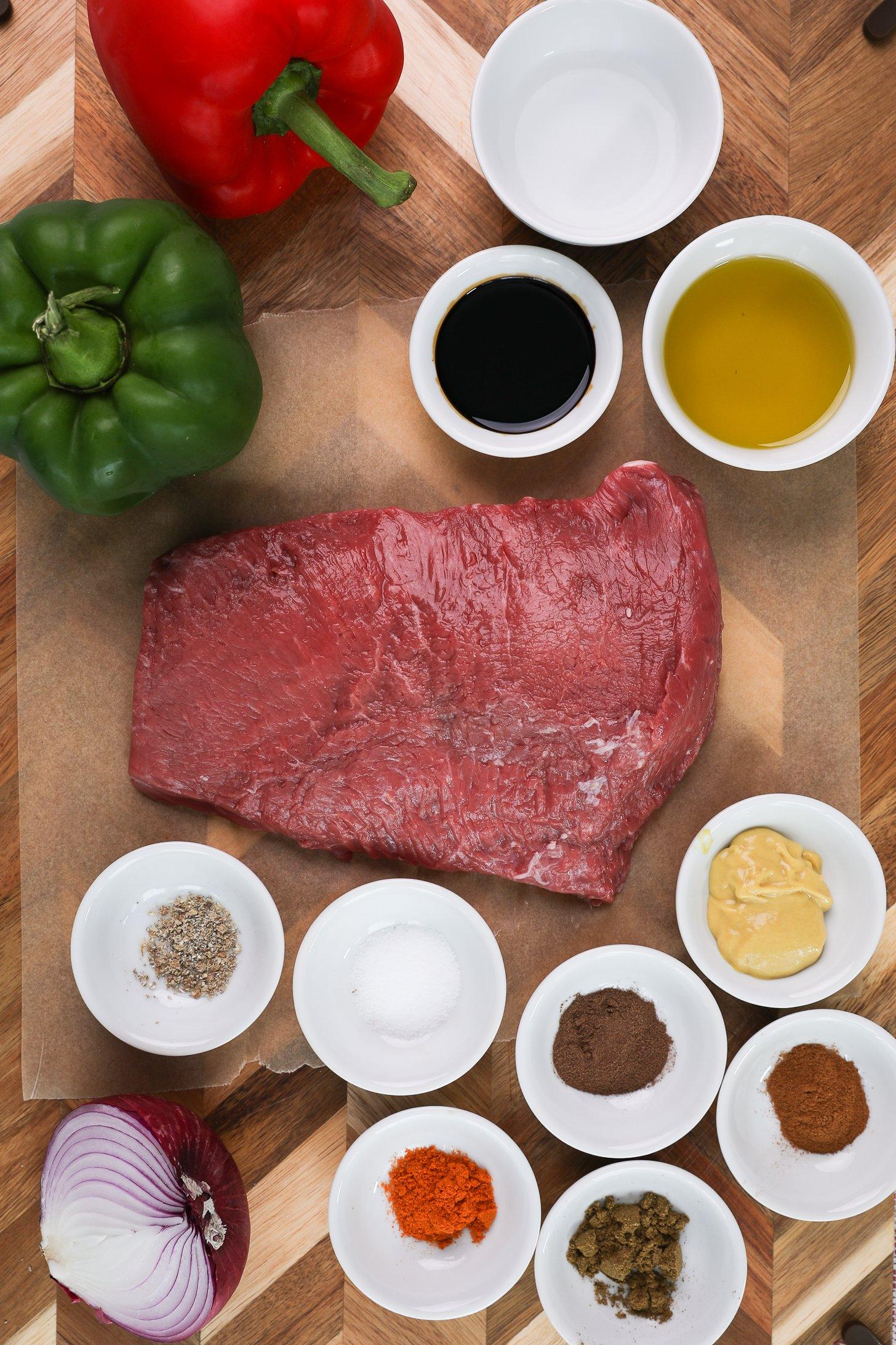 A selection of grilling food ingredients like sirloin beef fillet, bell peppers, onion, oil, spices, soy. sauce, vinegar and mustard.
