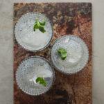 An image of 3 glasses filled with ice, water and basil seeds with sprigs of mint in each.