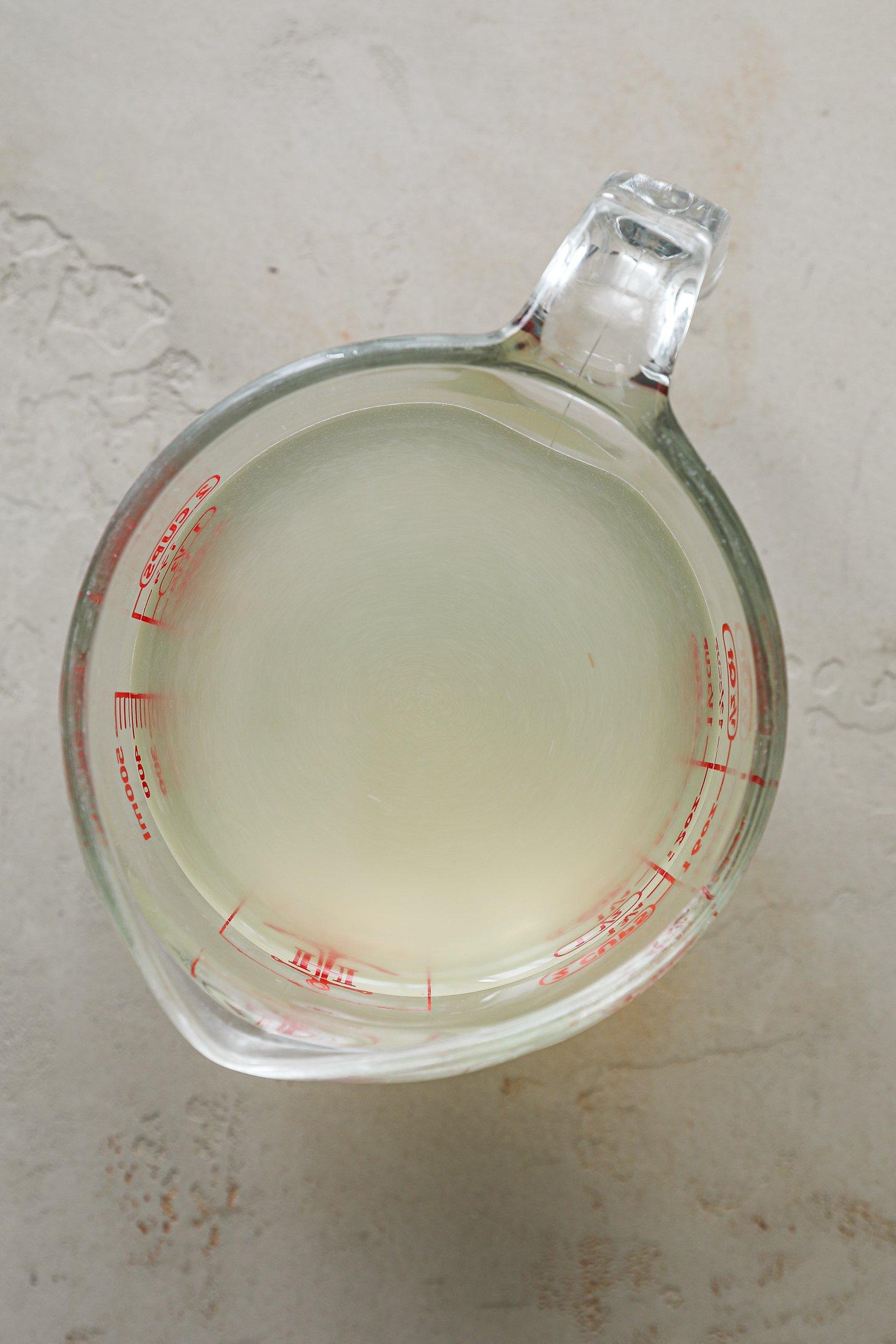 An image of a measuring jug filled with pale coloured liquid.