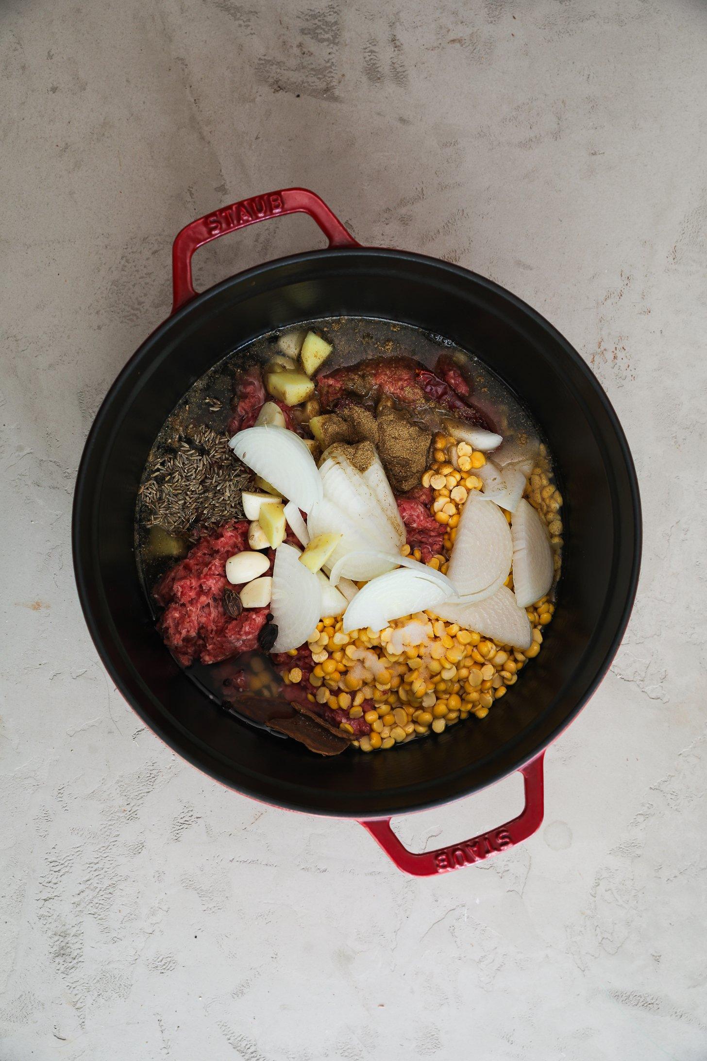 Ground beef, chana dal, onion, and spices in a Dutch oven.