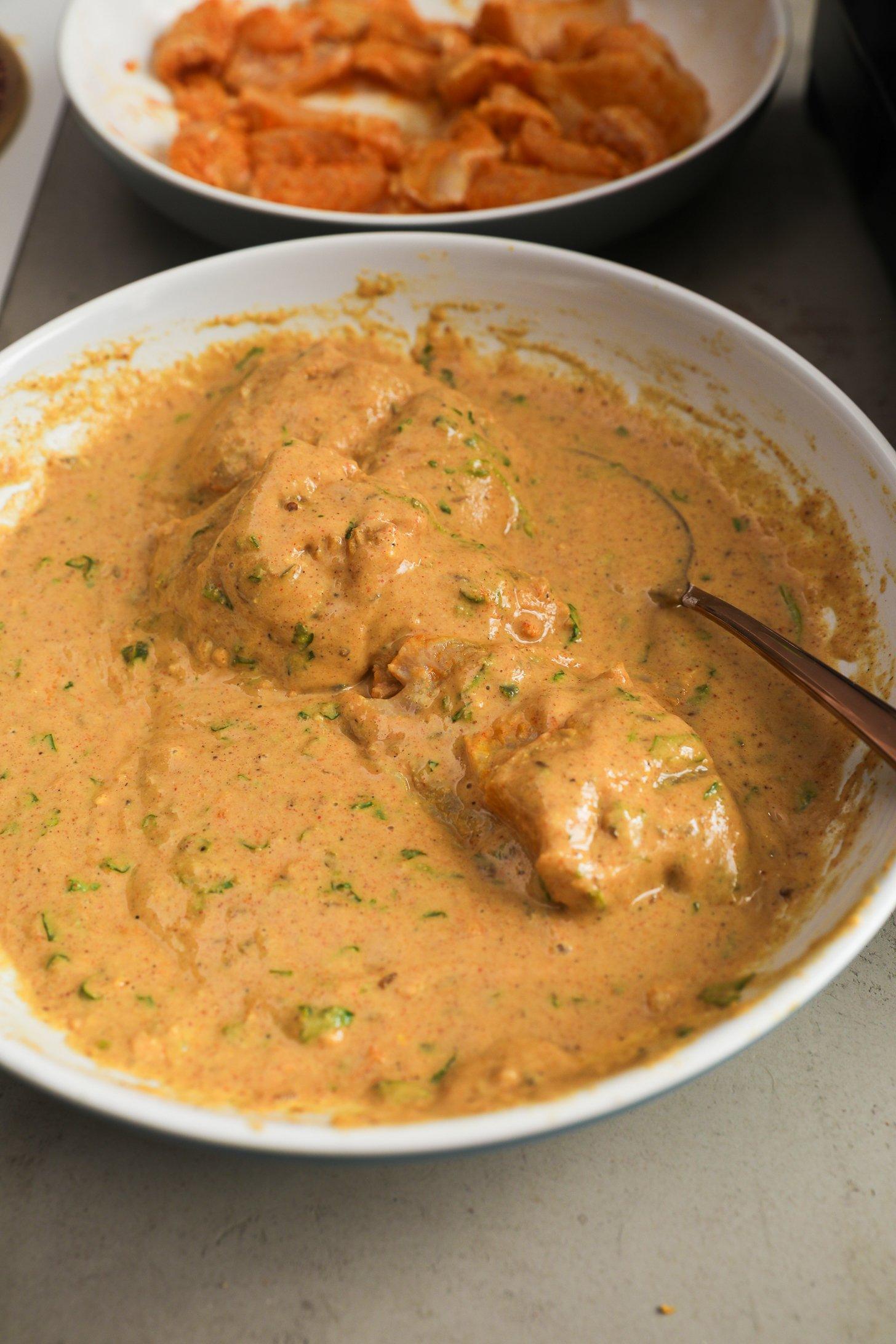 Basa fish pieces coated in spiced chickpea flour batter in a white bowl.