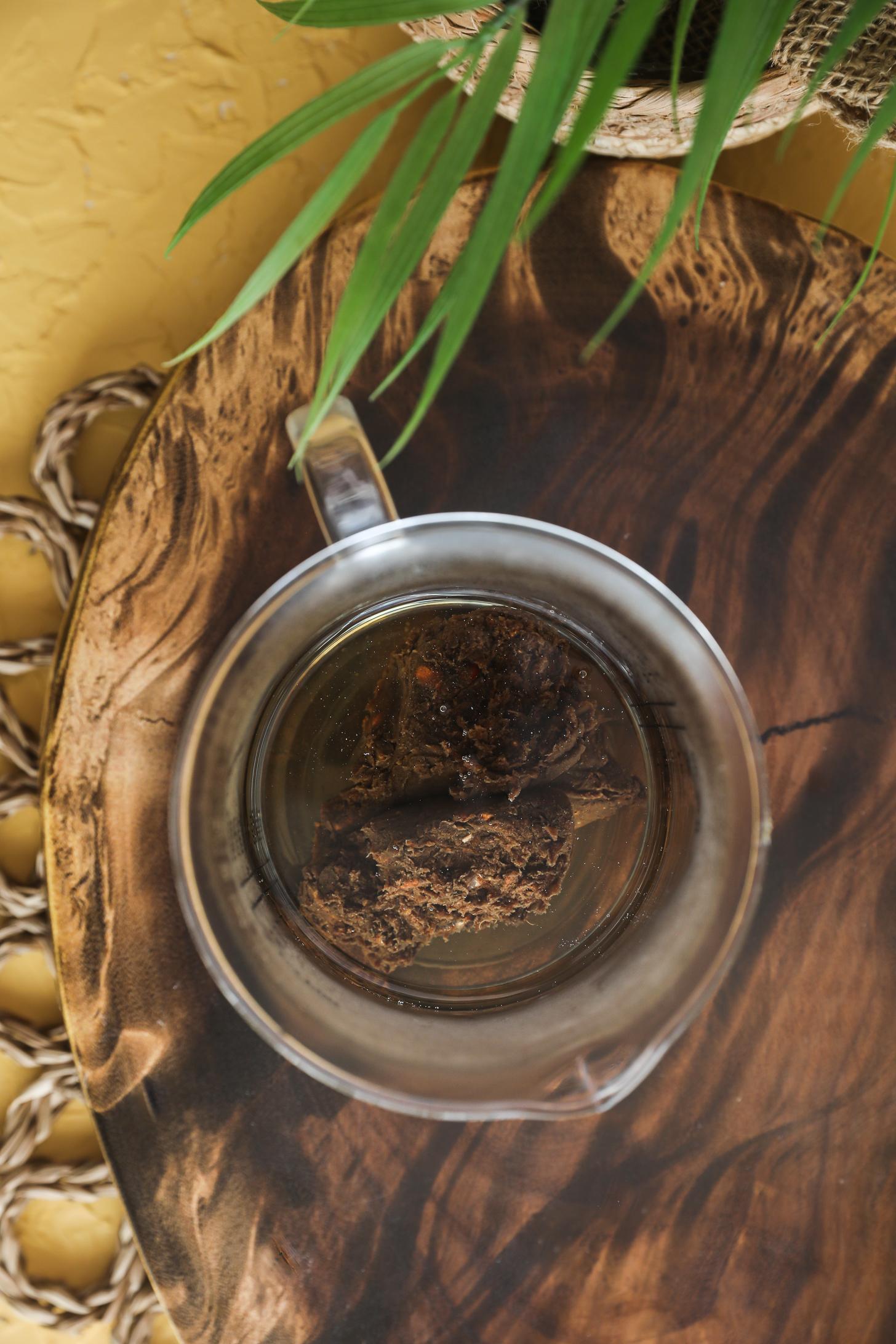 Tamarind paste in a glass jug with hot water for softening before straining.